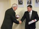 Jan Chudzikiewicz wrecza Burmistrzowi Ozimka dyplom i medal przyznany Gminie Ozimek.